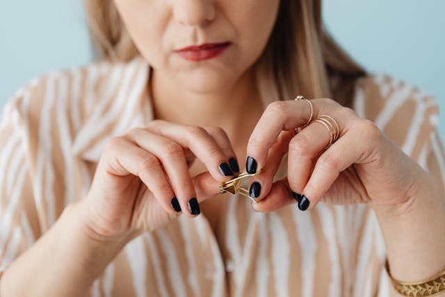 A Woman fidgeting with a out of shape paper clip