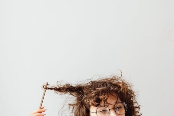 Should You Disclose Your Neurodivergence at Work? I woman staring outward twirling her hair with a pencil creating a mindless knot