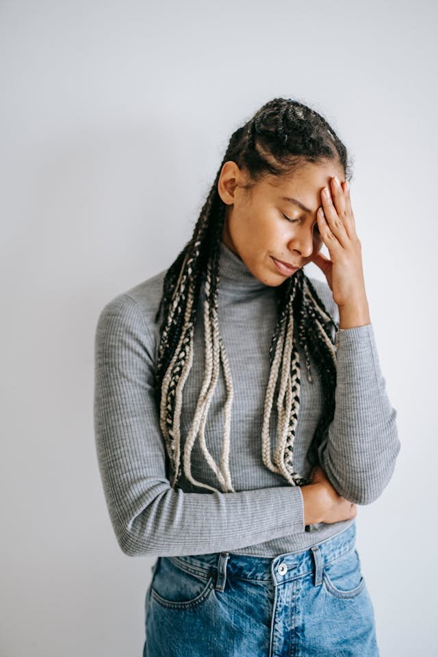 A woman, Holding her face with her eyes closed