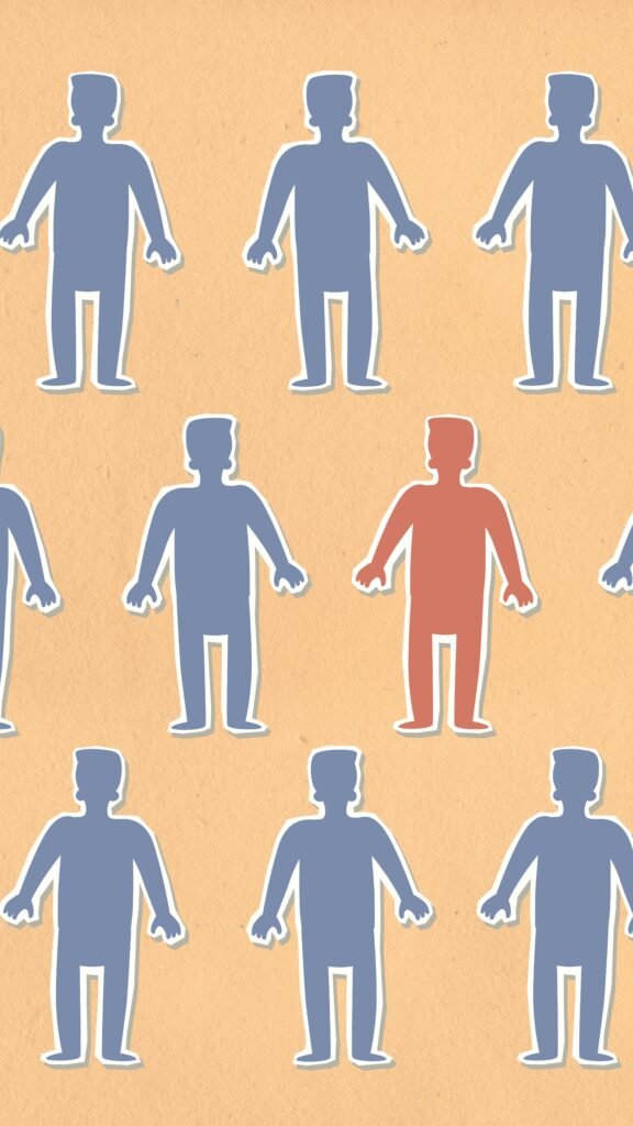 Cutouts of humans all being blue with the exception of one in red, showing that they are different
