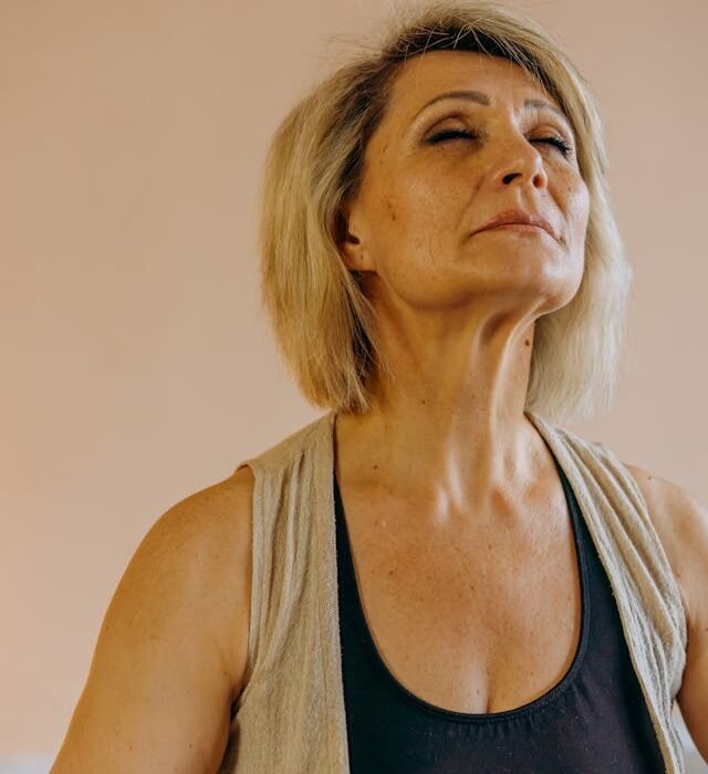 A middle aged woman looking up and looking like she is trying to hold her world inside her