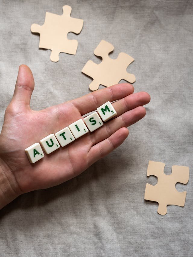 Autism displayed as lettered tiles on the palm of a person's hand