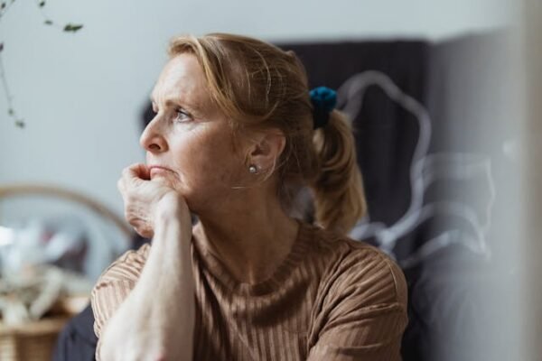 A woman propping sorrows looking out a window