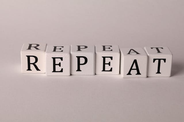 An image of  Cubes of letters forming the word repeat