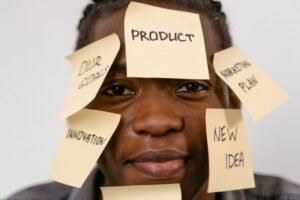 A man with various sticky notes over his face with different words like Product, Creative, New Idea