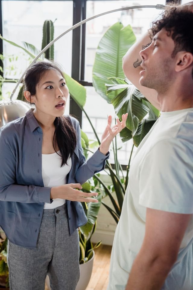 A man and a woman with the woman disagreeing with the man and the man holding his head in dispair.